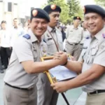 Petugas Kantor Pertanahan Kota Makassar menyerahkan piagam apresiasi kepada pegawai berprestasi usai upacara peringatan 65 Tahun UUPA di halaman kantor, Rabu 24/09/2025