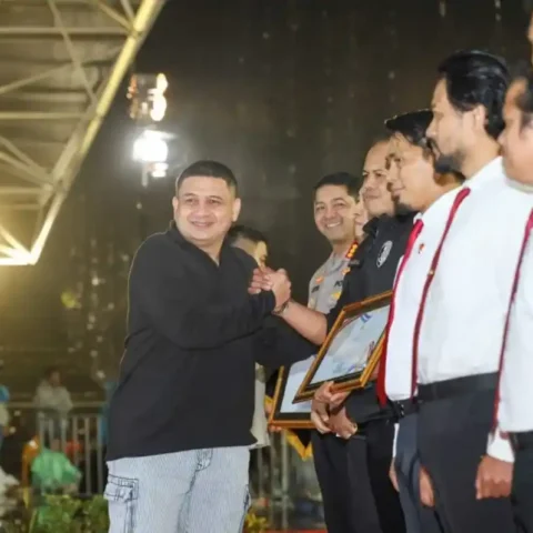 Wali Kota Makassar Munafri Arifuddin menyalami perwakilan kepolisian saat penyerahan penghargaan Jatanras pada puncak HUT ke 418 Kota Makassar di Karebosi.