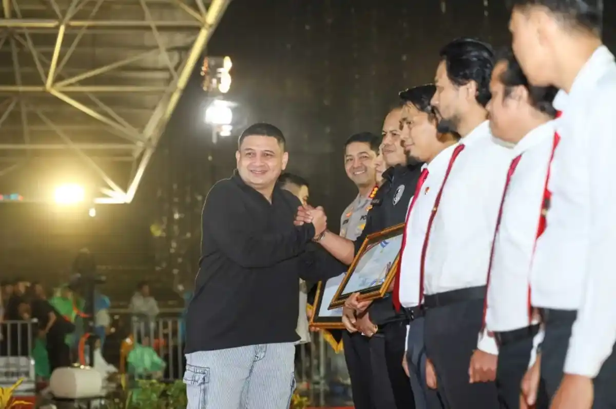 Wali Kota Makassar Munafri Arifuddin menyalami perwakilan kepolisian saat penyerahan penghargaan Jatanras pada puncak HUT ke 418 Kota Makassar di Karebosi.