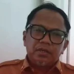 Pejabat Pemkot Makassar berbaju dinas cokelat memberi pernyataan di koridor kantor terkait rencana pemusnahan kendaraan rongsok di Balai Kota