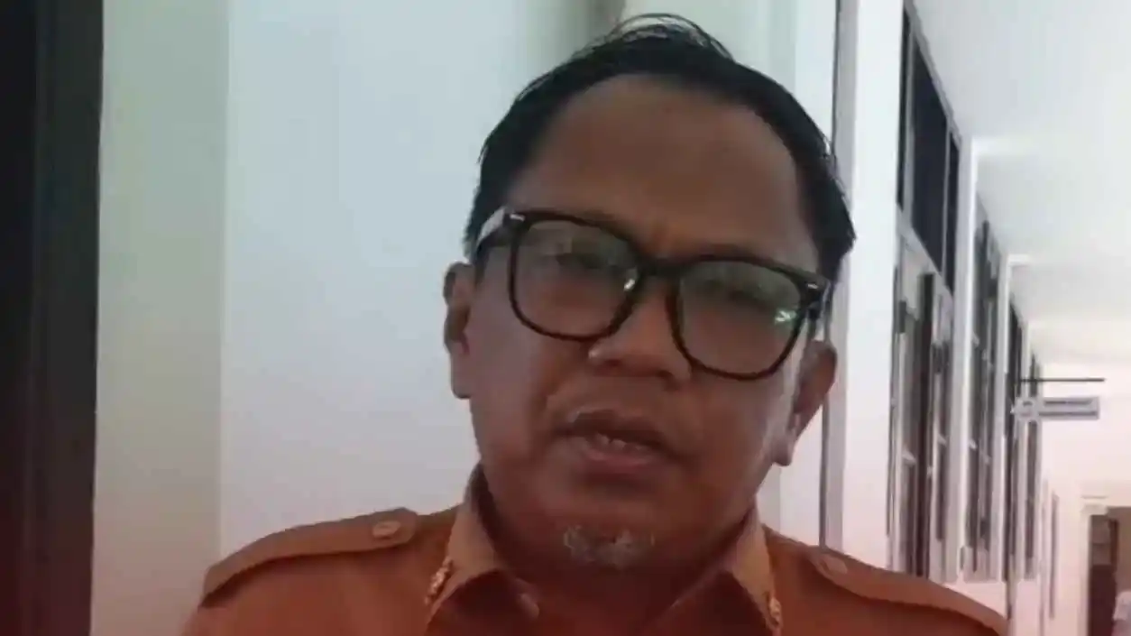 Pemkot Makassar Siapkan Pemusnahan Kendaraan Rongsok di Balai Kota 1 Pejabat Pemkot Makassar berbaju dinas cokelat memberi pernyataan di koridor kantor terkait rencana pemusnahan kendaraan rongsok di Balai Kota
