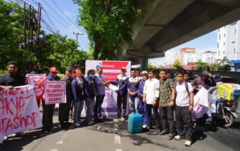 Massa SPRINDO Migas Sulawesi dan aktivis CLAT membawa poster saat unjuk rasa soal Pertashop di Makassar, 03/11/2025