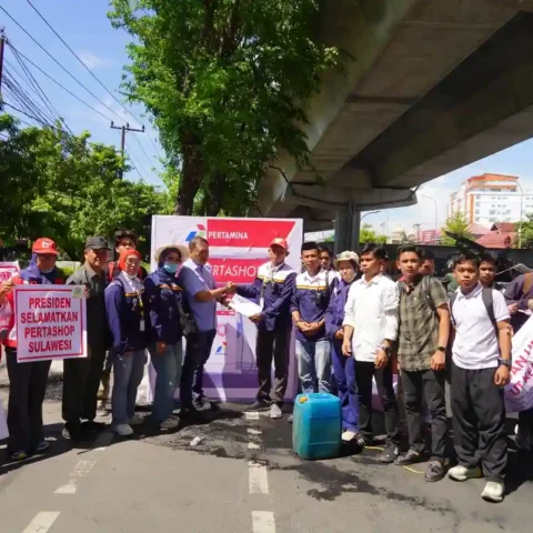 Massa SPRINDO Migas Sulawesi dan aktivis CLAT membawa poster saat unjuk rasa soal Pertashop di Makassar, 03/11/2025