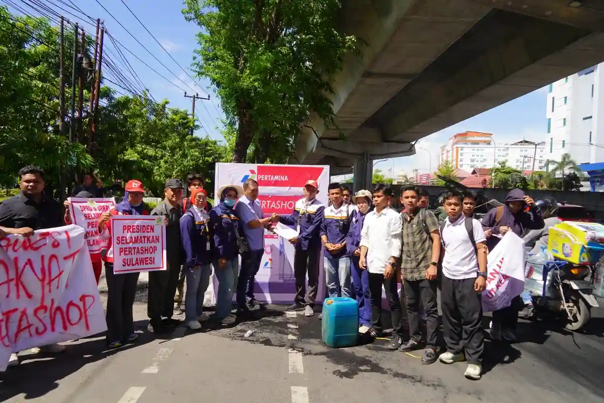 Massa SPRINDO Migas Sulawesi dan aktivis CLAT membawa poster saat unjuk rasa soal Pertashop di Makassar, 03/11/2025