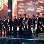 Penerima penghargaan Tax Award 2025 Makassar berpose dengan simbol kunci di panggung
