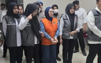 Sitti Husniah Talenrang mengenakan rompi oranye saat dikawal petugas di Polda Sulsel